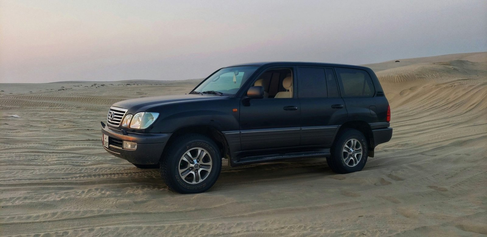 a black suv parked in the middle of a desert